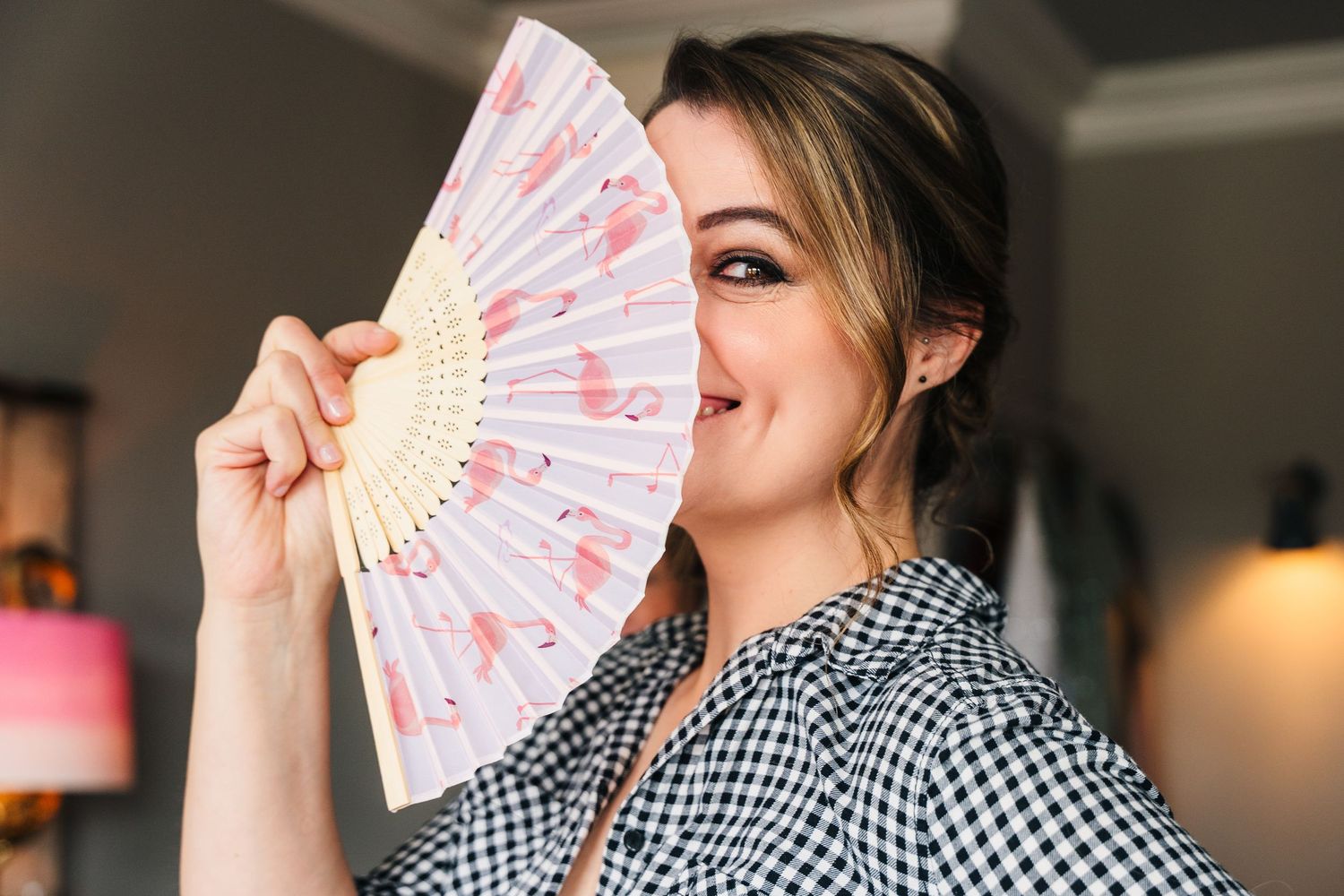 Someone holds up a decorative pink and white folding fan in an indoor setting. House Dublin Wedding Photographer