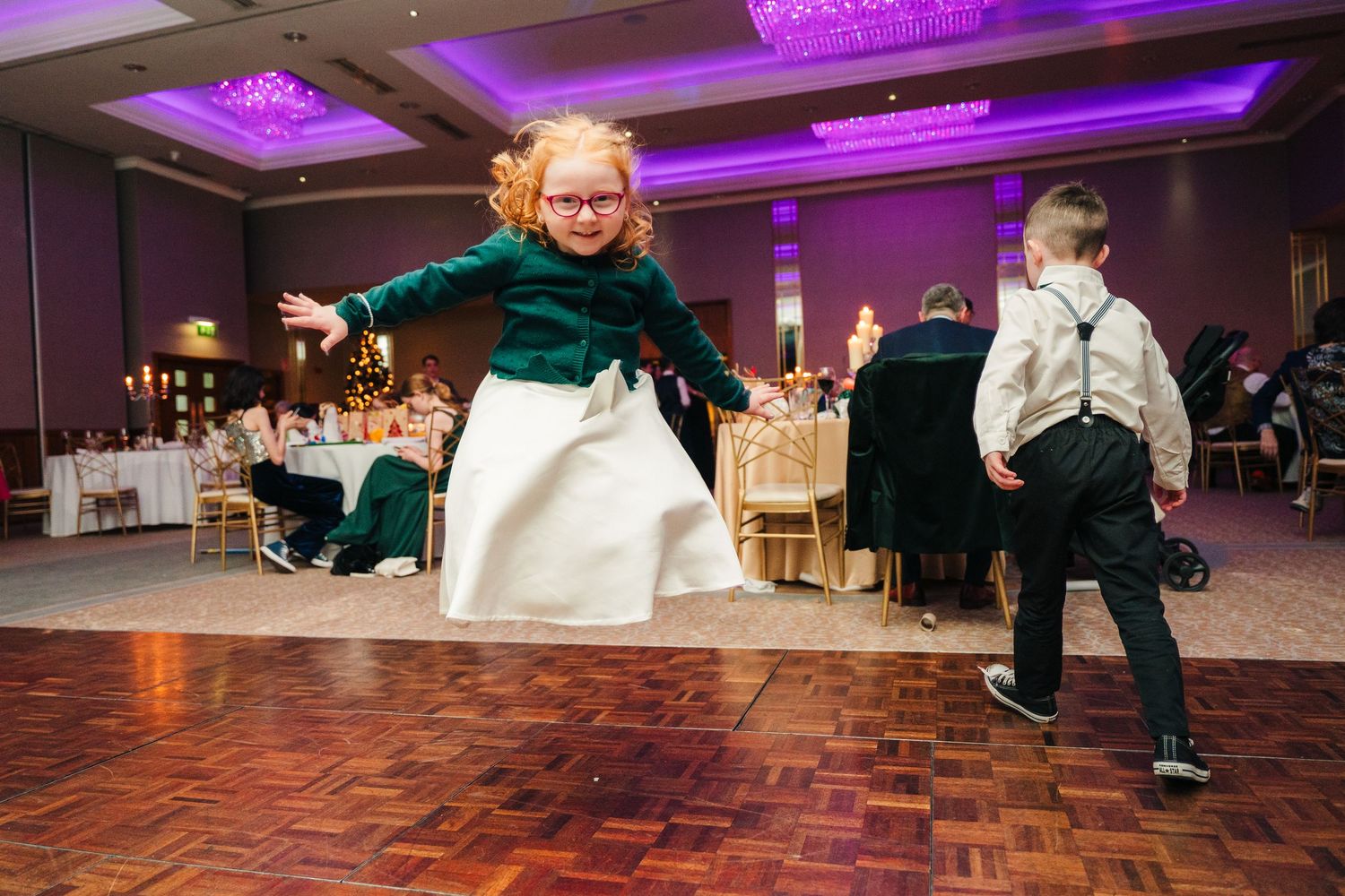 Dynamic dance party sequence showing guests enjoying the reception under purple ceiling lighting.  Wedding PHOTOGRAPHER Trim Castle