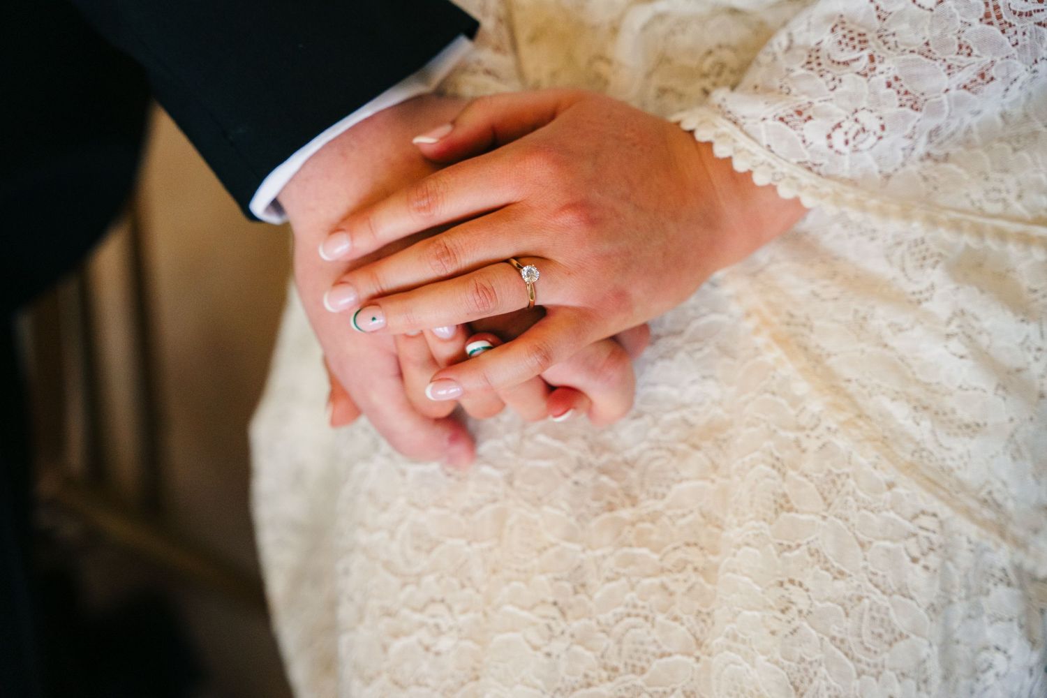 Delicate details of a white lace wedding dress being adjusted in closeup shots. Wedding Photography Trim Castle Ireland