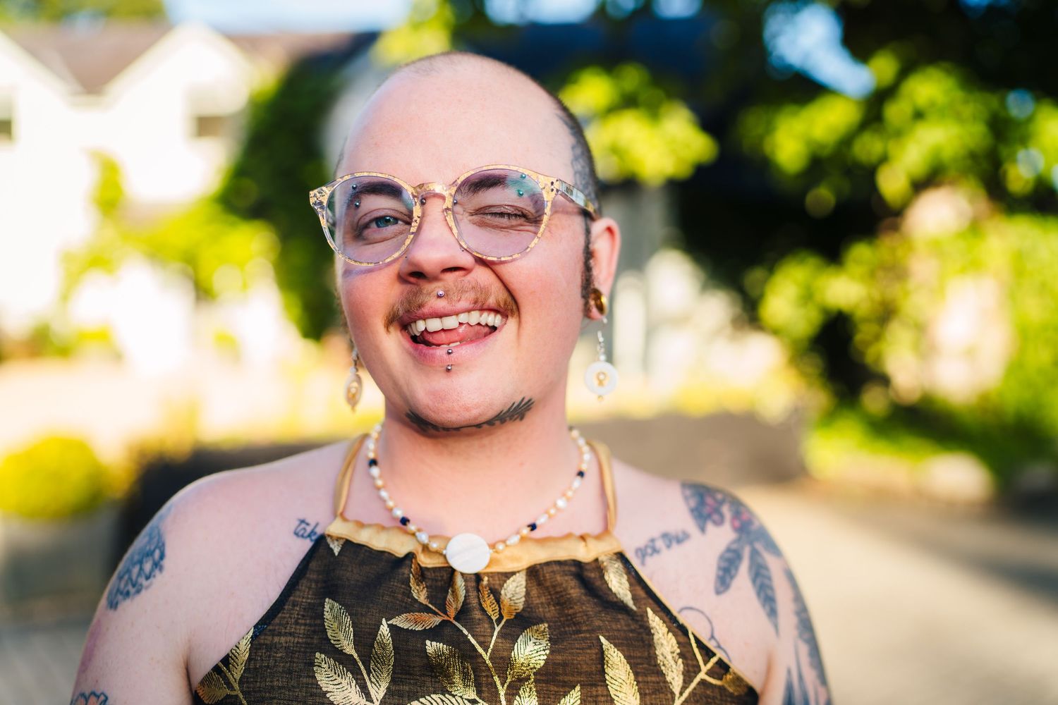 Poulaphouca Wedding photographer wicklow  Portrait of person in floral top with glasses and tattoos smiling in summer sunlight.