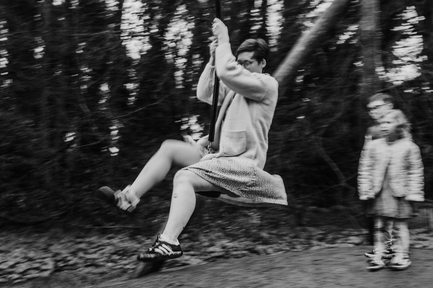 Family photographer Dublin Ireland  Black and white sequence showing joyful playtime movements on playground equipment.