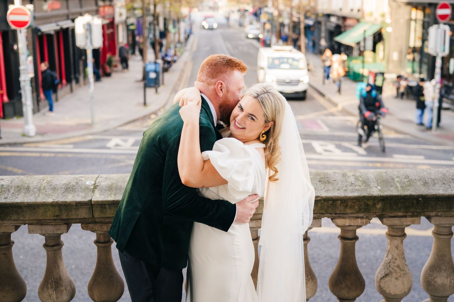Romantic wedding couple shares intimate moments along a historic stone balustrade in an urban setting. Wedding photographer dublin