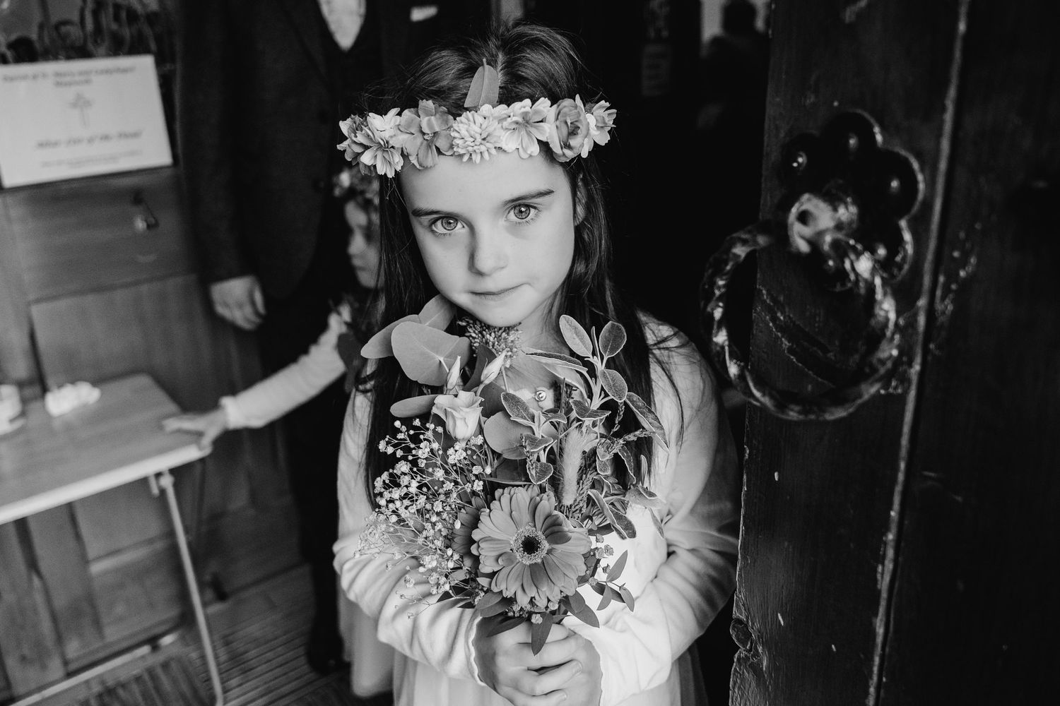Black and white portraits of flower girls wearing floral crowns and delicate dresses.