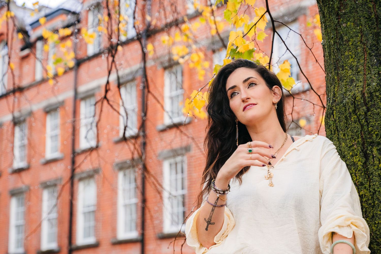 Autumn fashion photoshoot in front of historic brick buildings with yellow fall foliage. professional headshots dublin photographer
