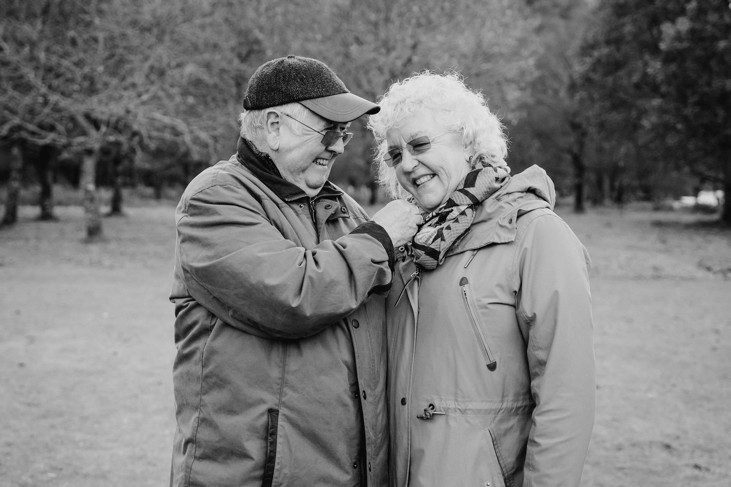 Vintage black and white photographs show tender moments between an elderly couple sharing laughter in a park setting. PHOTOGRAPHER Dublin ir