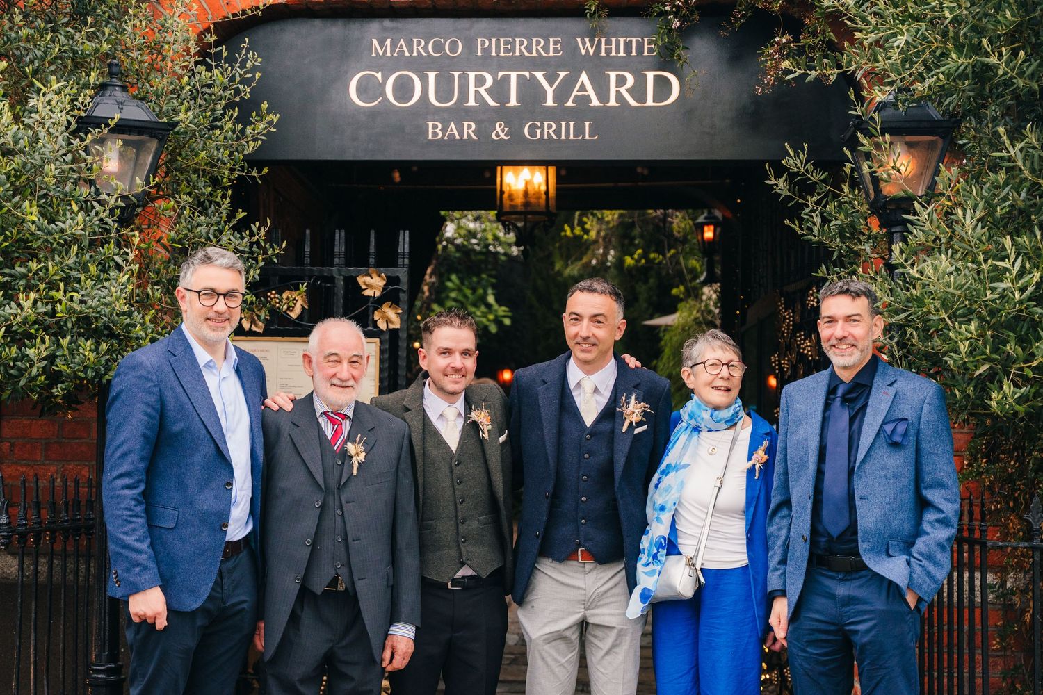 Group photo of wedding party members outside Marco Pierre White restaurant. Marco Pierre Dublin Wedding Photographer