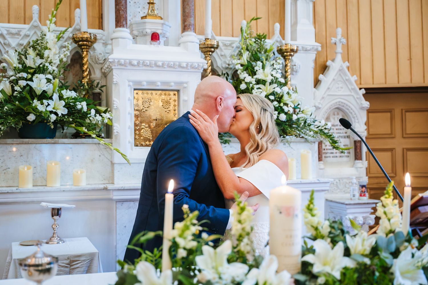 A series of artistic wedding ceremony photos showing a church altar decorated with white flowers and candlelight. The Dean Dublin Wedding Ph