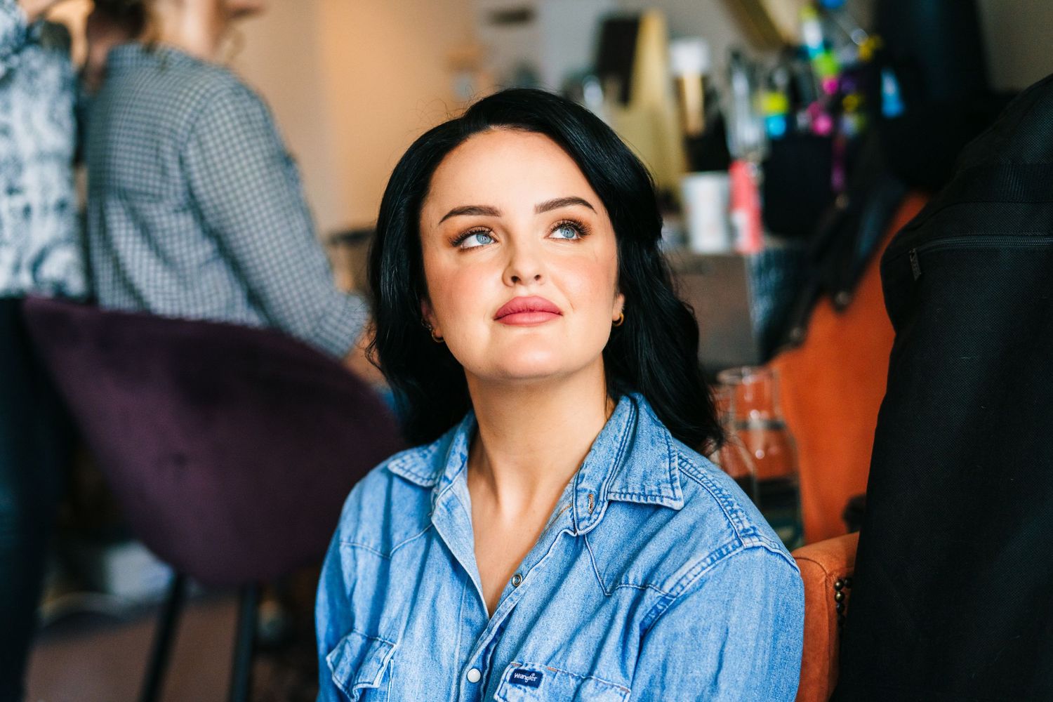 A person wearing a denim shirt sits in front of a dark background. House Dublin Wedding Photographer