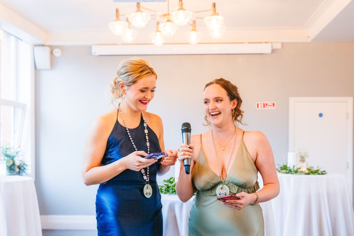 Two bridesmaids in elegant dresses share a joyful moment at a wedding reception. PHOTOGRAPHER Dublin Ireland Wedding