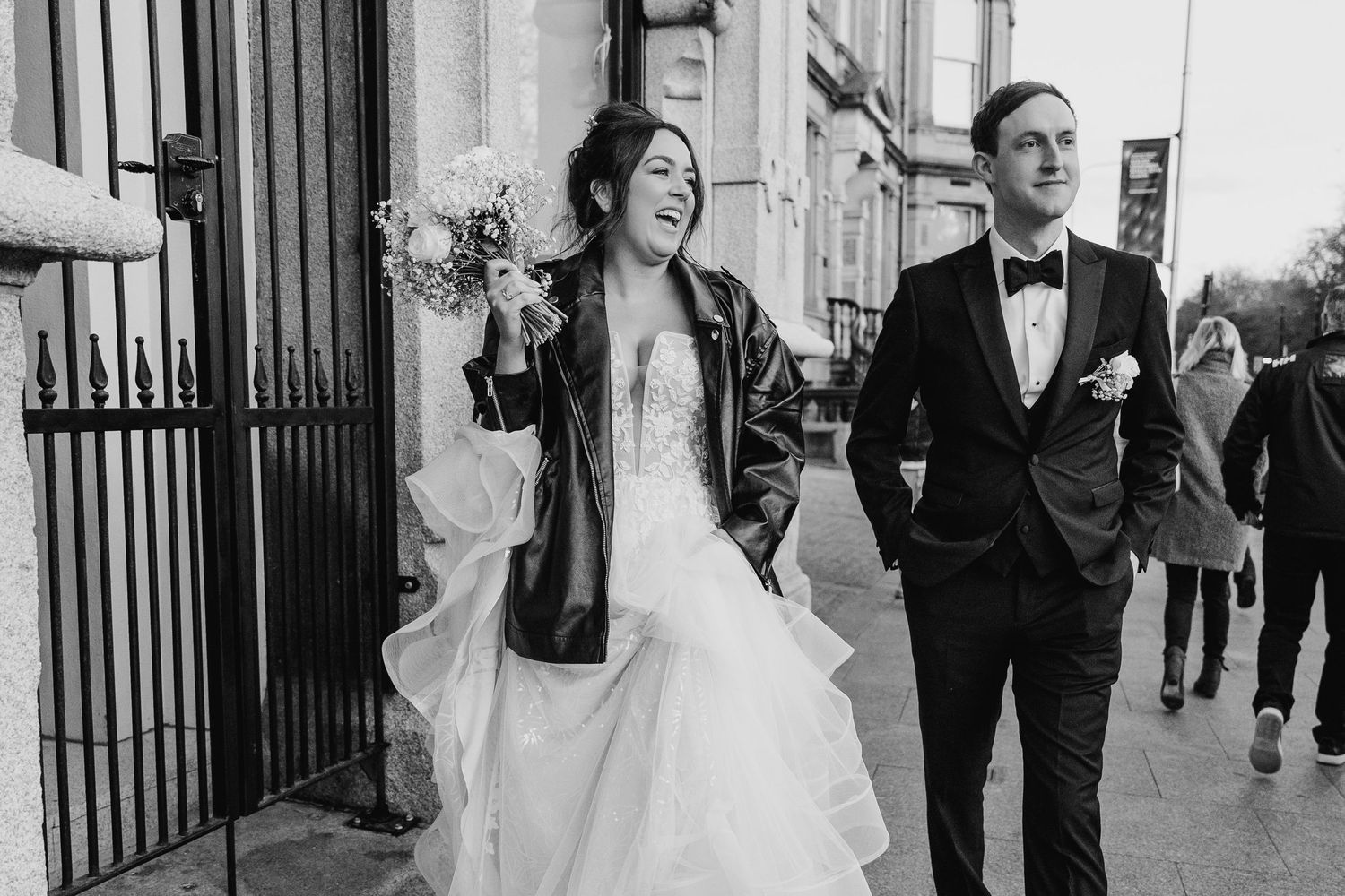 Casual wedding portrait with couple strolling down city street in black and white. Wedding PHOTOGRAPHER Dublin