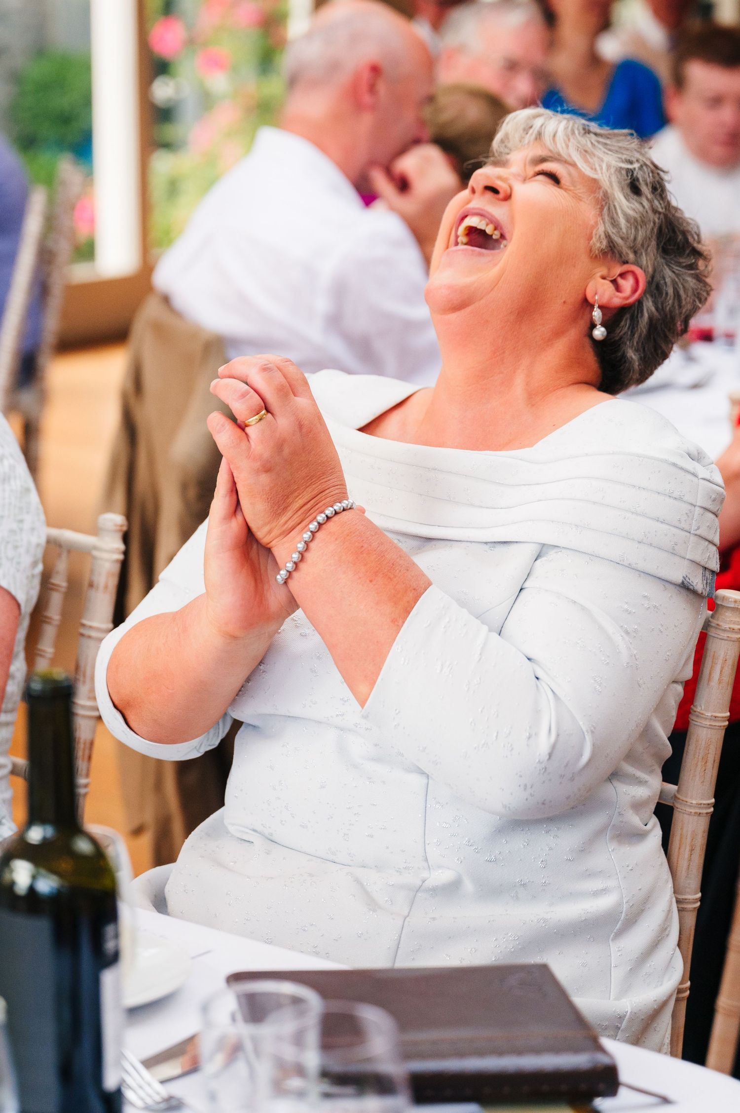 Millhouse slane wedding photographer dublin Series of candid laughing moments captured during festive celebration in white attire.