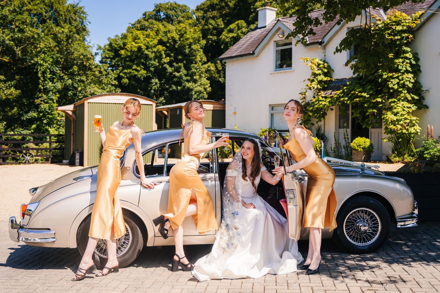 Poulaphouca Wedding photographer wicklow Wedding party posing with classic car on sunny day.