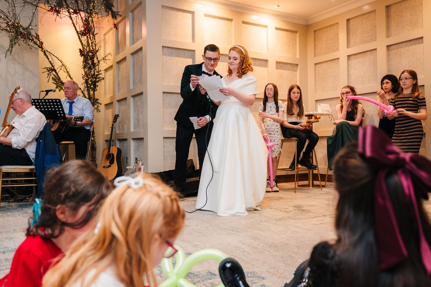 Wedding reception dance party with guests celebrating in a wood-paneled ballroom.  Wedding PHOTOGRAPHER Trim Castle