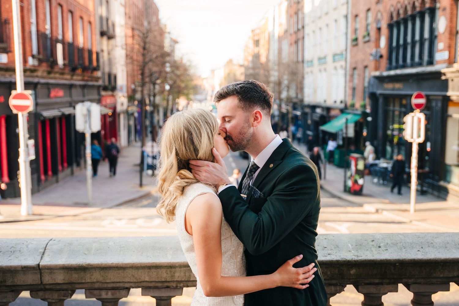 Couple embracing on city street during golden hour. City Hall Dublin wedding photogrAPher