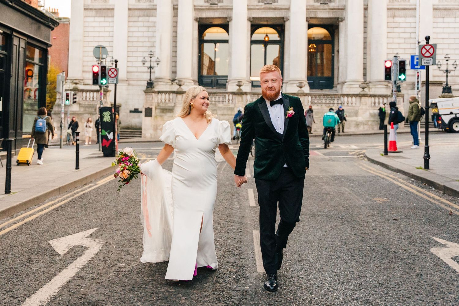 A happy couple walks together on a city street after their wedding ceremony in Dublin, Ireland.