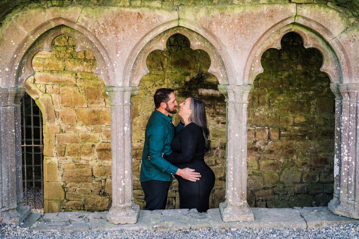 Panoramic view of a historic stone cloister with multiple arched columns and alcoves. Family PHOTOGRAPHER Dublin