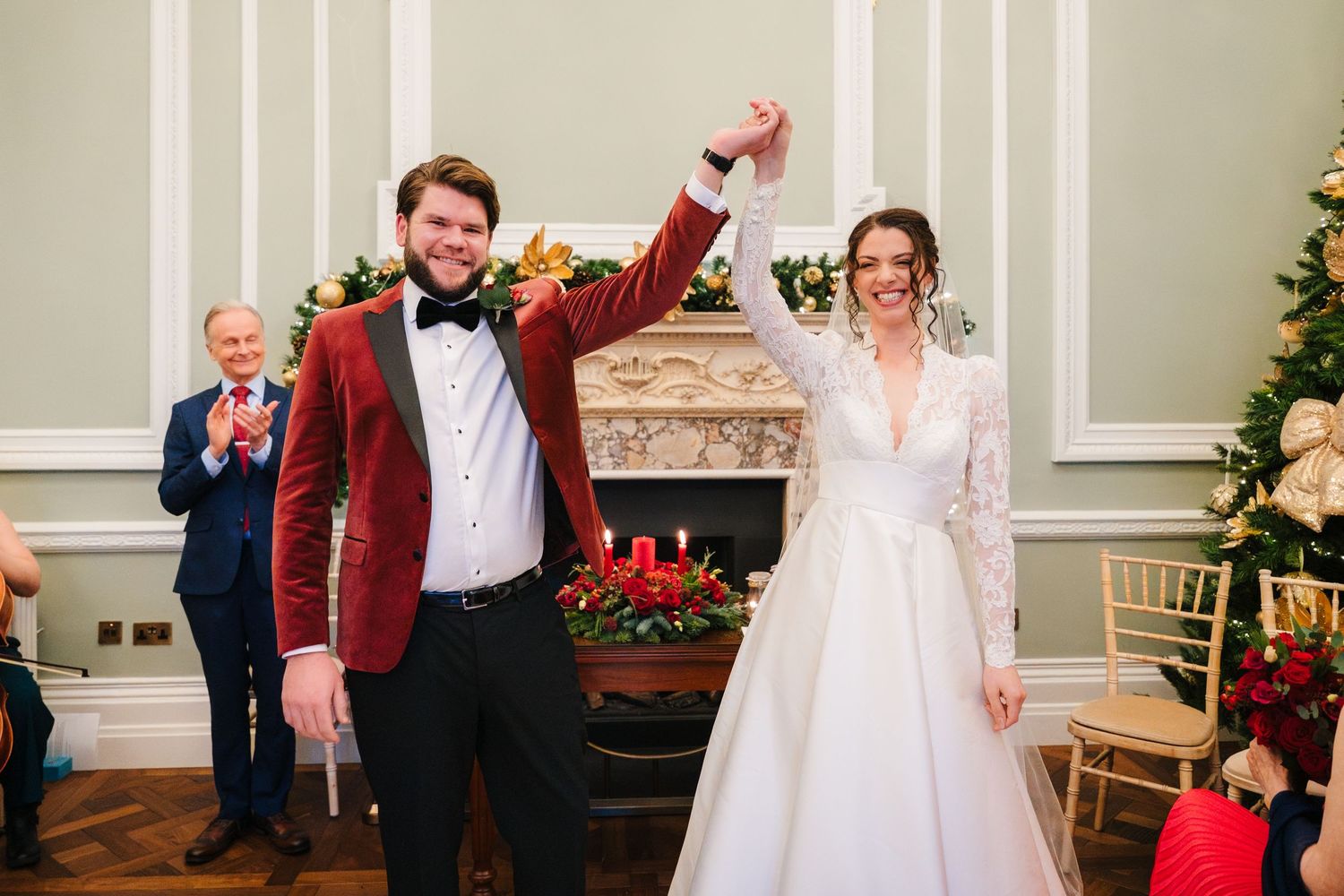 Wedding party celebrates in an elegant room with ornate moldings and Christmas decorations. Stephens green club dublin Wedding photographer