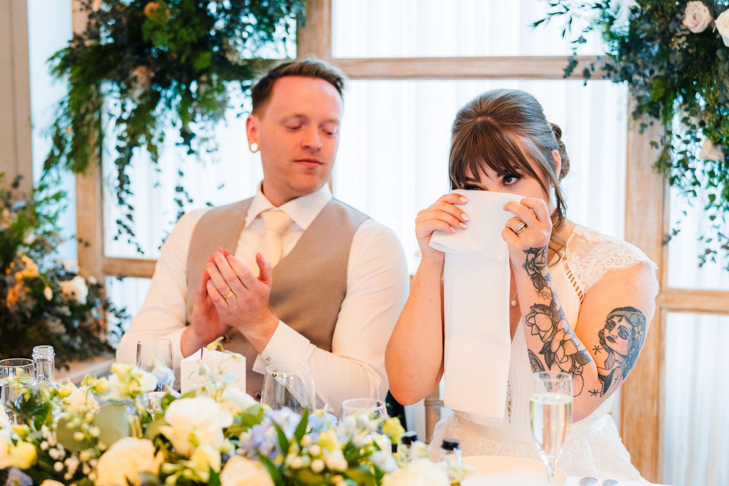 Couple reacts emotionally during wedding reception speech at decorated dining table. PHOTOGRAPHER Dublin Ireland Wedding