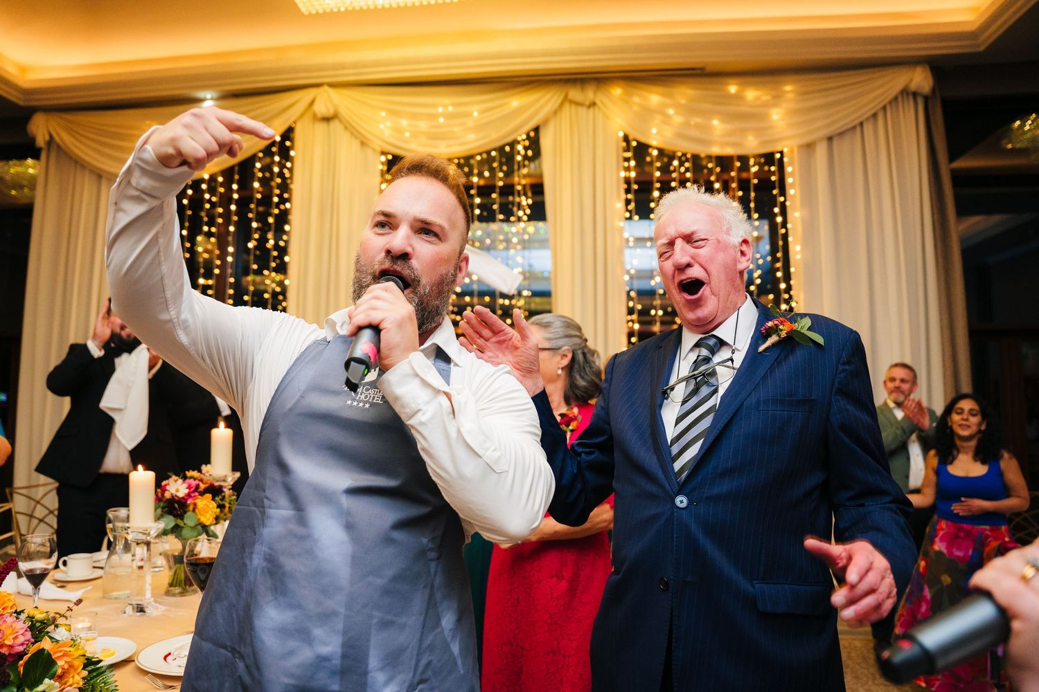 Wedding reception guests celebrating and dancing under warm lighting and decorative drapes.Wedding Photography Trim Castle Ireland\