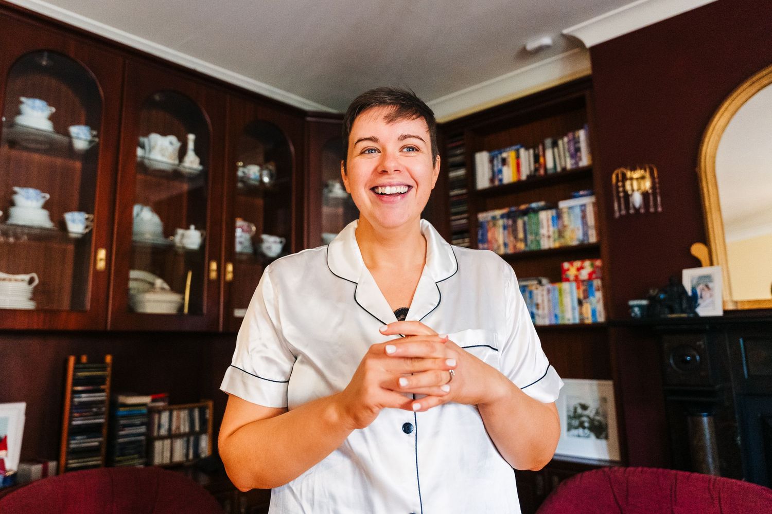 Staff in white uniforms interacting with customers at a restaurant with wooden decor and bookshelves. Millhouse slane wedding photographer d