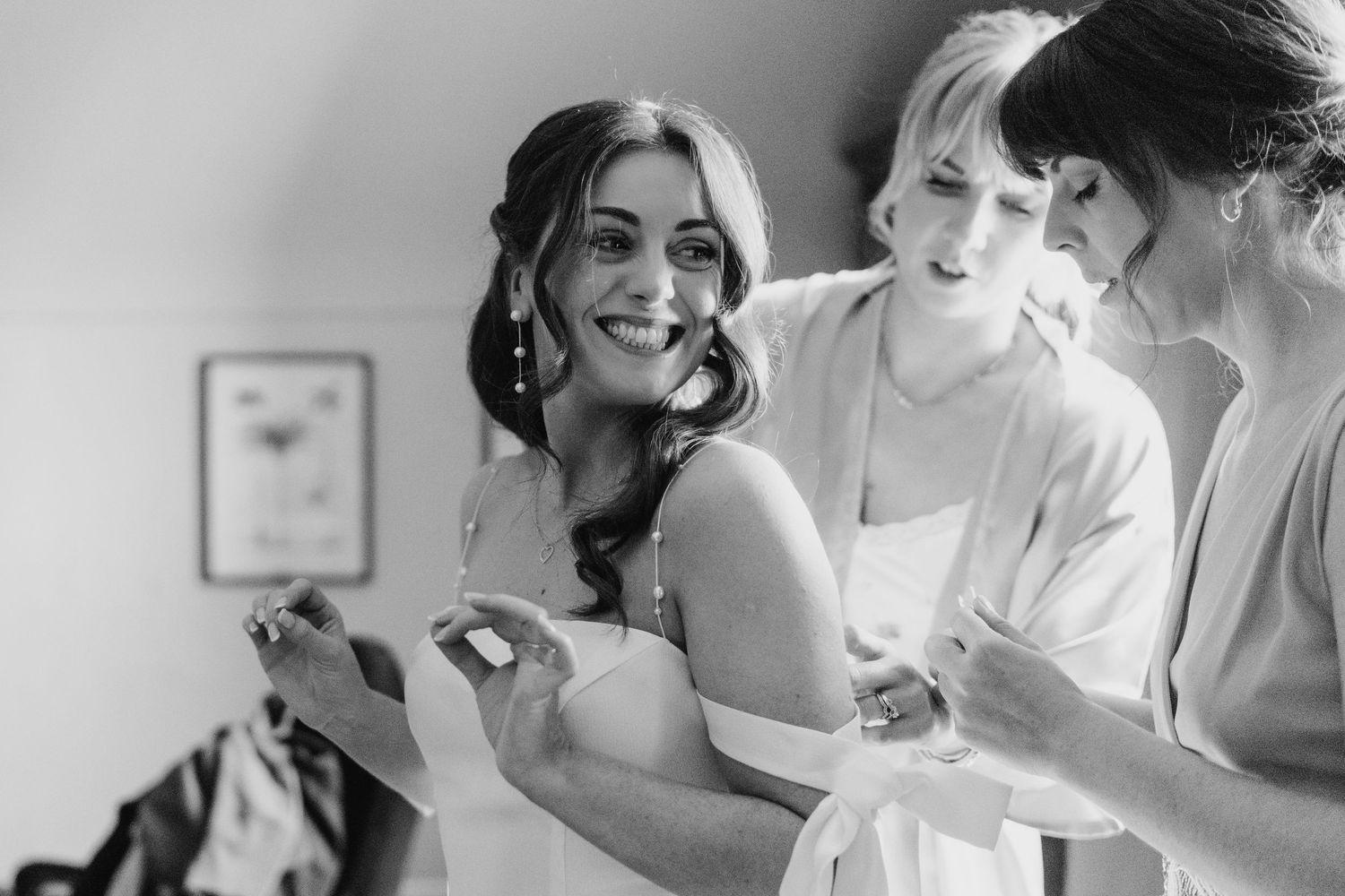 Castle Leslie Wedding Photographer Dublin Black and white photo showing bridal party getting ready with joyful smiles in a dressing room.