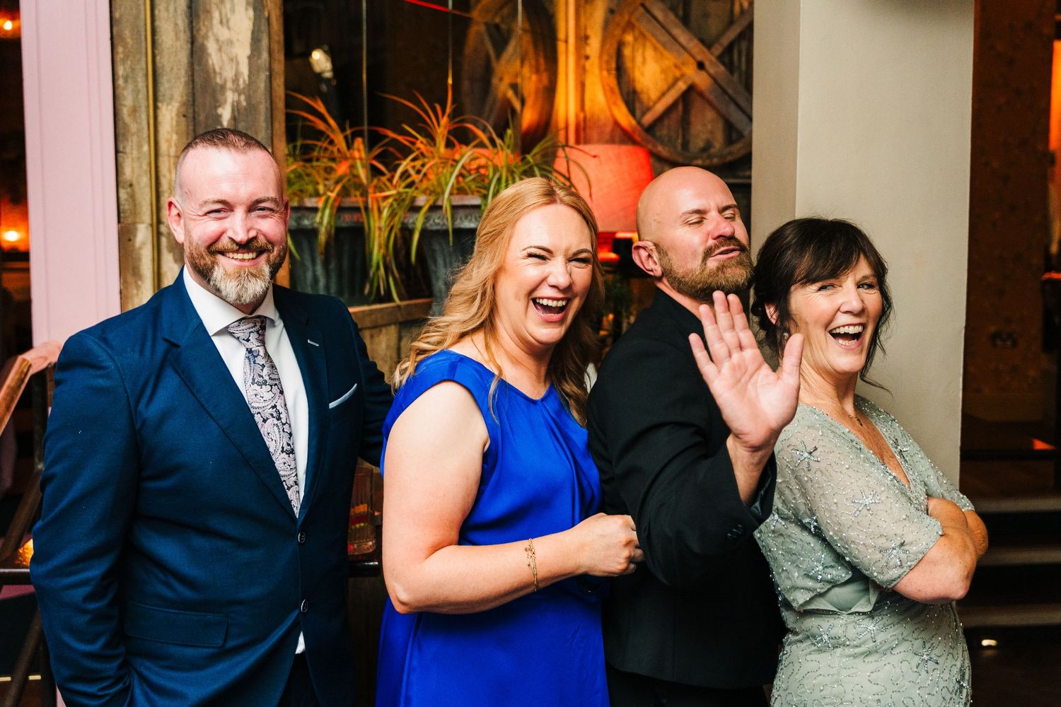 Four wedding guests share a candid laughing moment at an evening reception. House Dublin Wedding Photographer