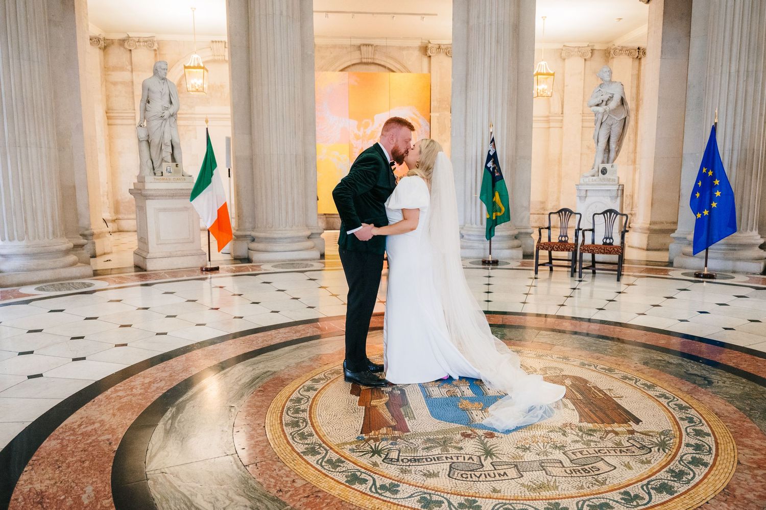 Elegant wedding couple dancing in a grand marble hall with ornate columns and decorative floor medallions. City Hall Dublin Photographer