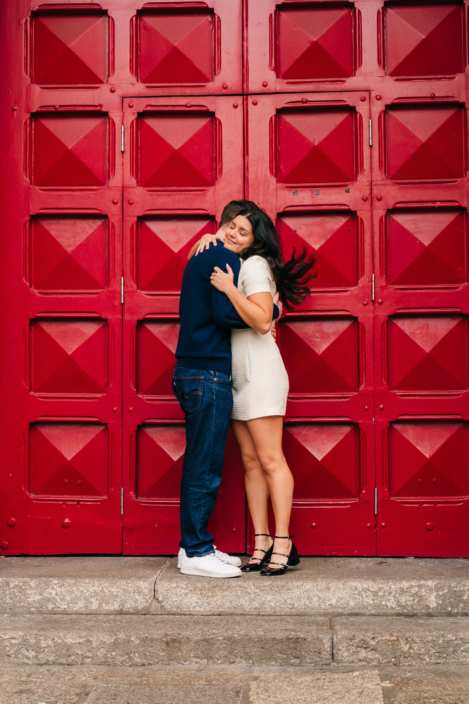 Couple sharing an intimate moment against a vibrant red geometric wall. Surprise proposal dublin photography