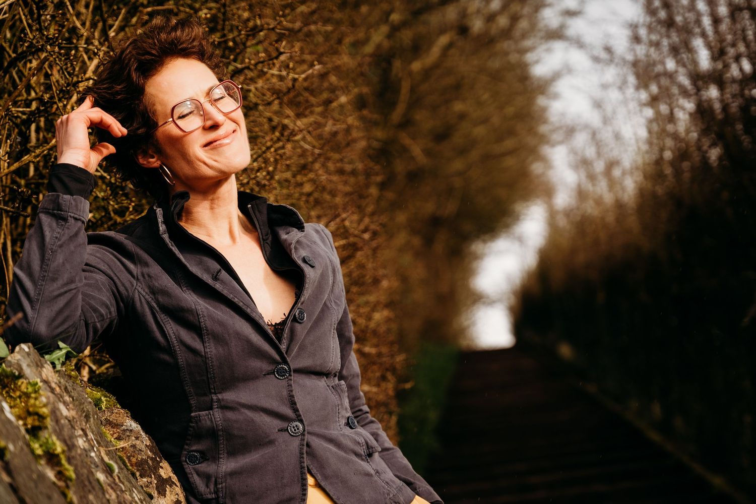 Person relaxing outdoors in a black jacket against an autumn path backdrop. Portrait PHOTOGRAPHER Dublin