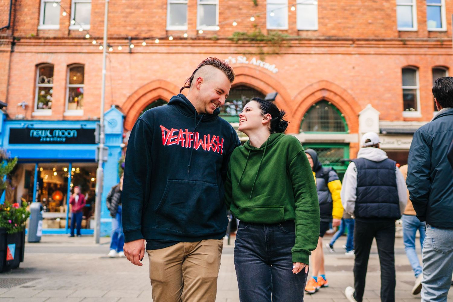 People interacting in front of a classic red brick building with Gothic architectural details. PHOTOGRAPHER Dublin Ireland