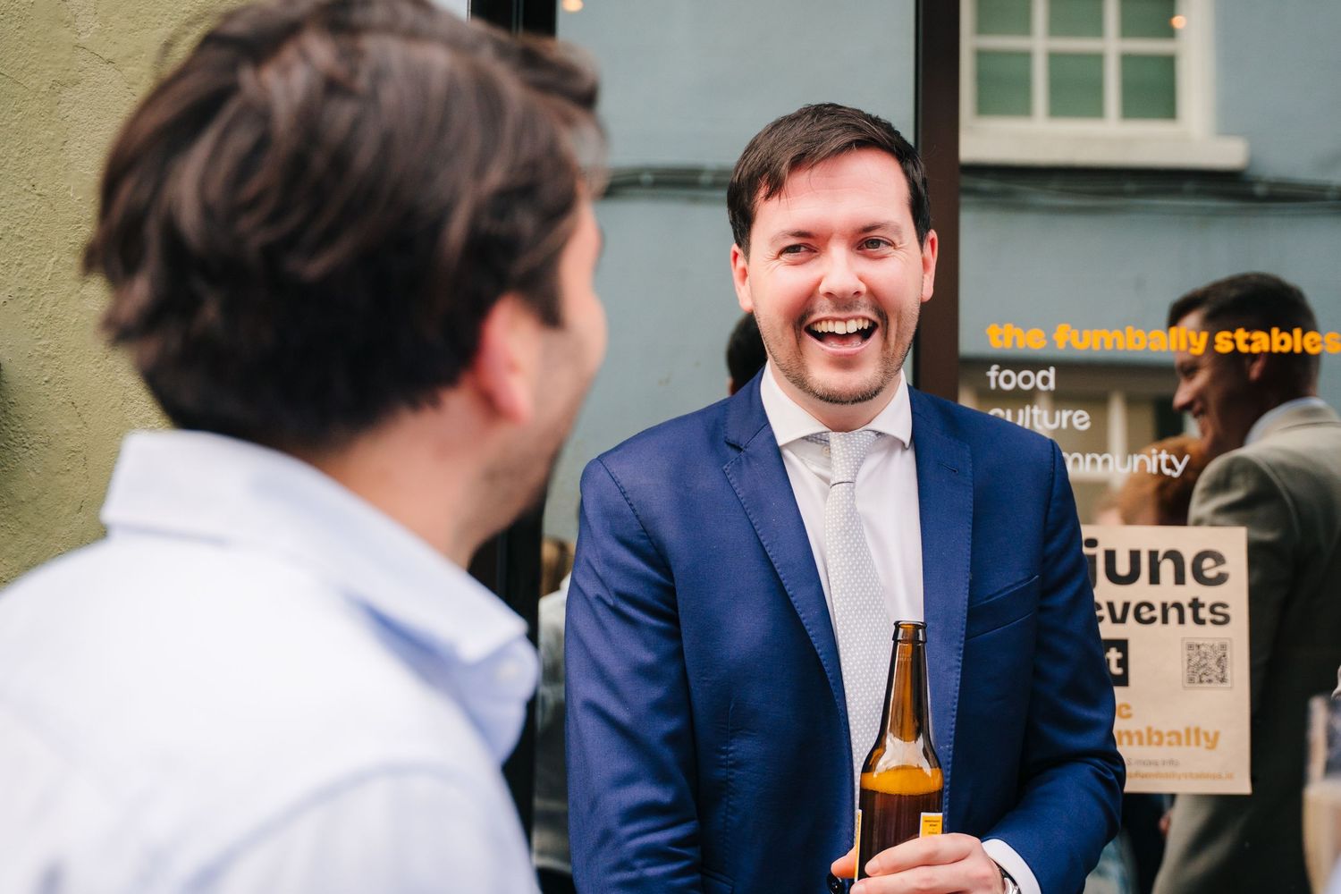 Wedding guests celebrate and share drinks during lively outdoor party. Same sex wedding PHOTOGRAPHER Dublin