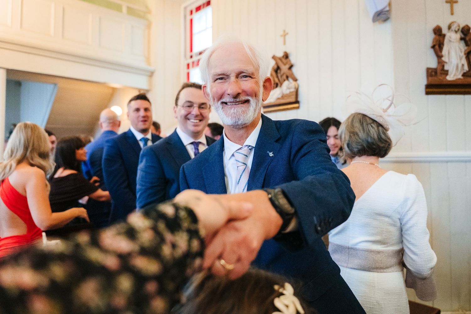 Guests gathered at a formal indoor event space celebrate and dance together during a festive celebration. The Dean Dublin Wedding Photograph