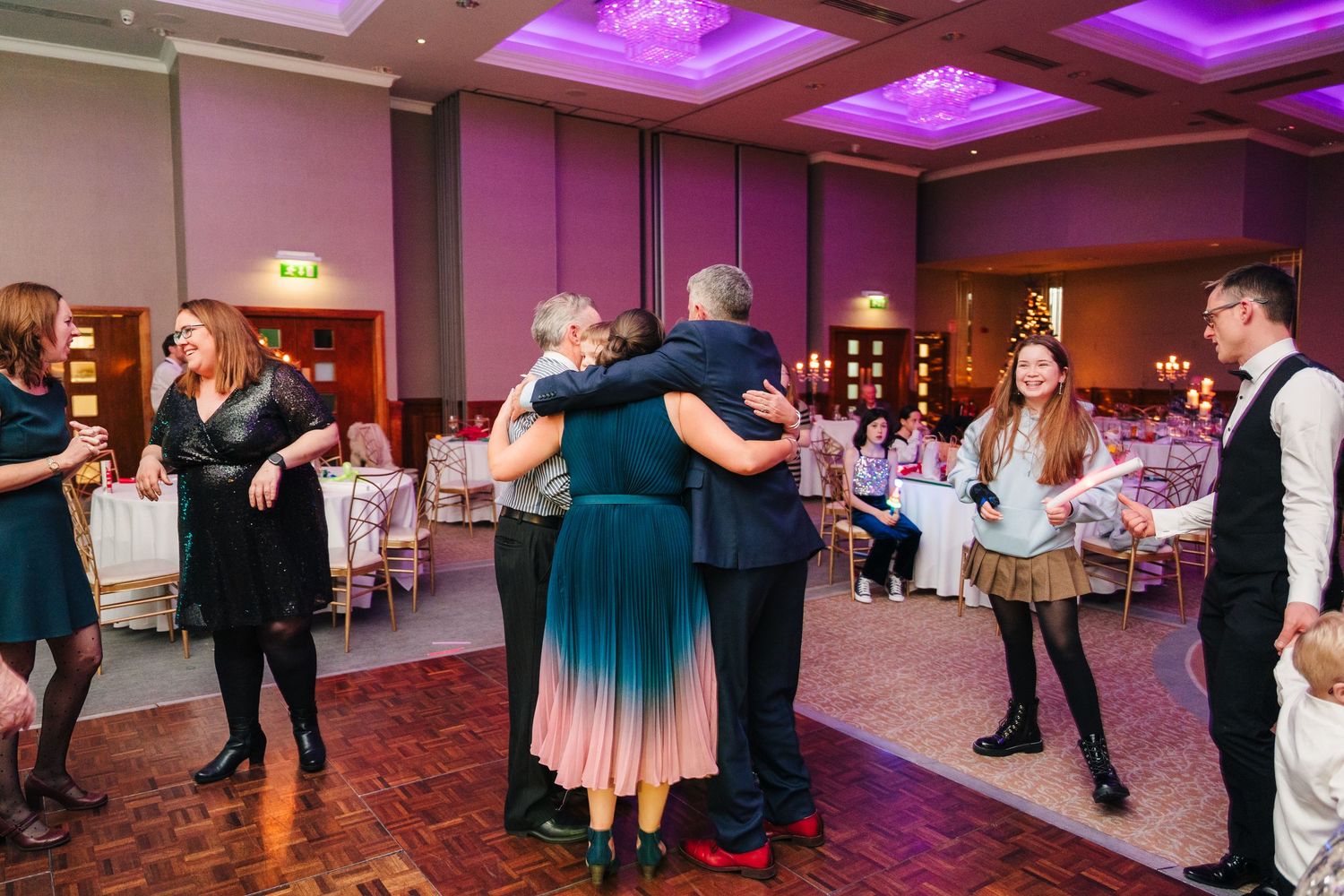 Wedding reception dance floor panorama with purple ambient lighting and guests in motion.  Wedding PHOTOGRAPHER Trim Castle