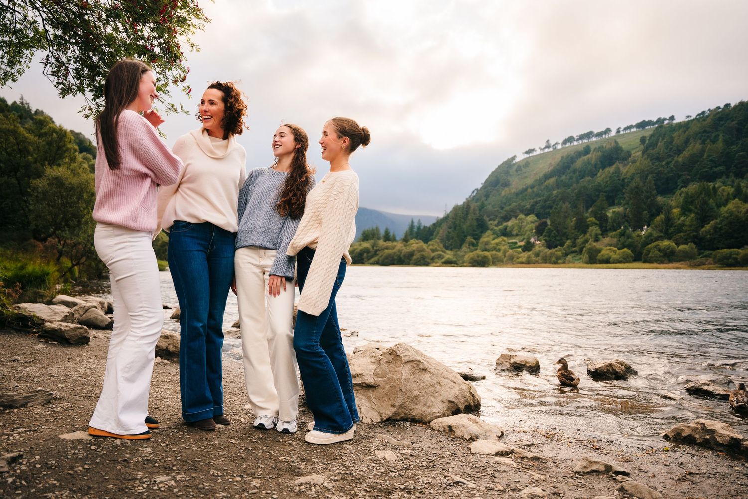 Family photographer Ireland Dublin A casual gathering on a scenic beach with mountains visible in the background.