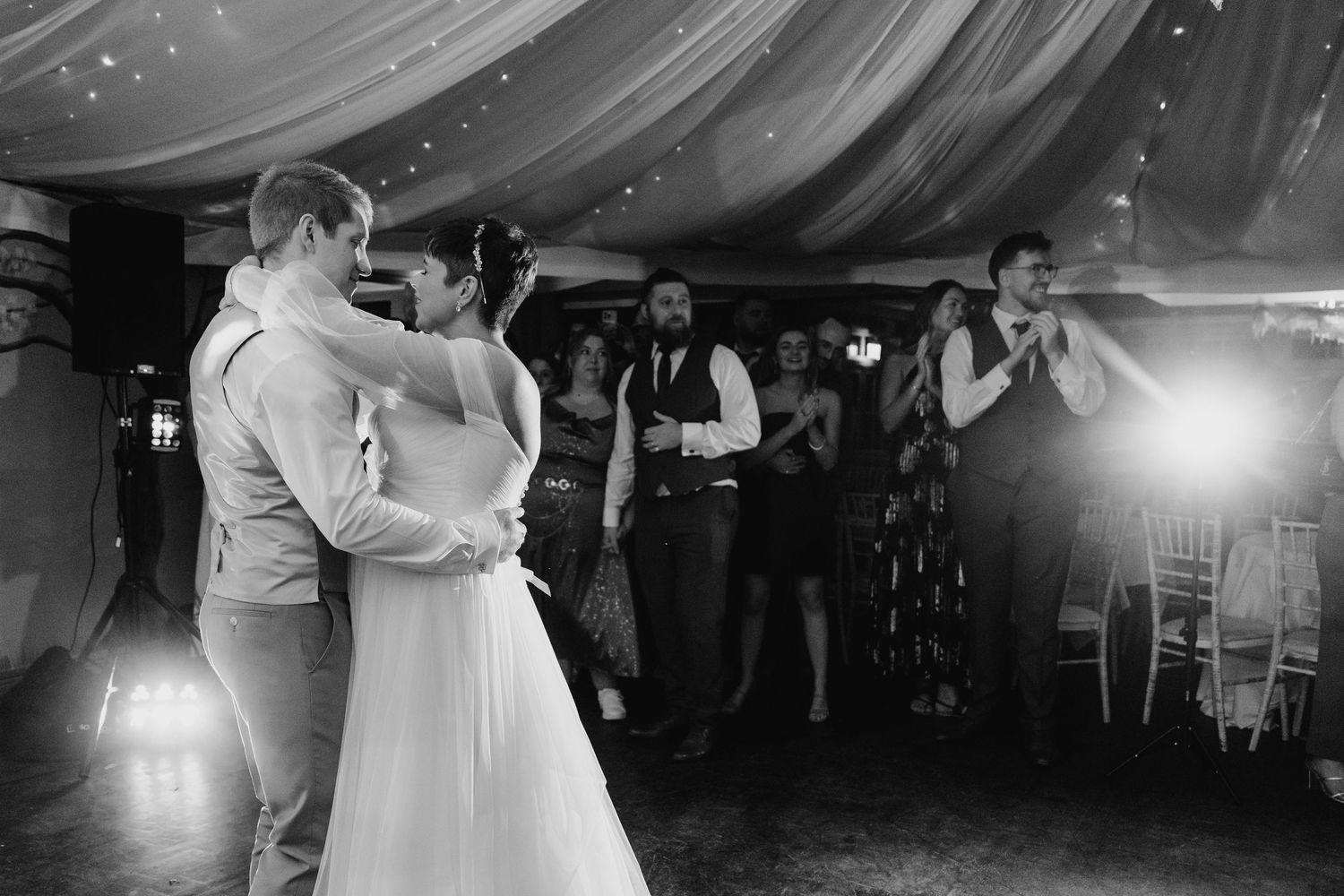 Millhouse slane wedding photographer dA couple shares their first dance under draped fabric and twinkling lights at their wedding reception.