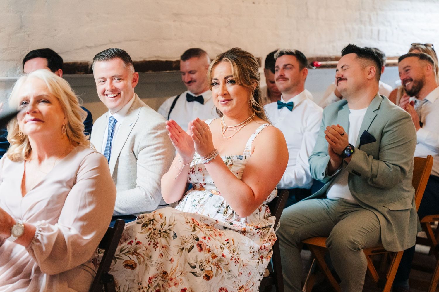Wedding guests laughing and reacting during a reception celebration. Same sex wedding PHOTOGRAPHER Dublin