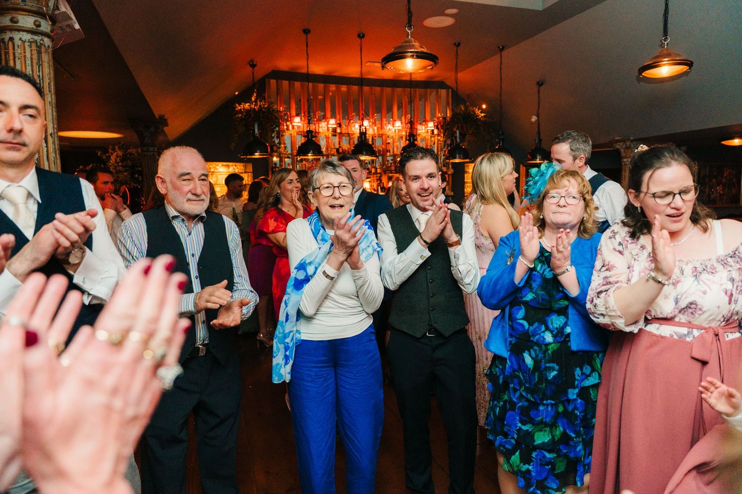 Wedding party cheering and celebrating together at a reception venue.