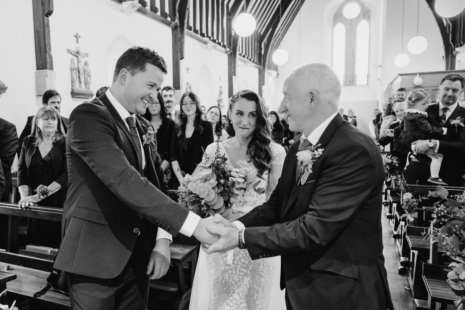 Emotional moments captured during a church wedding ceremony with guests looking on.