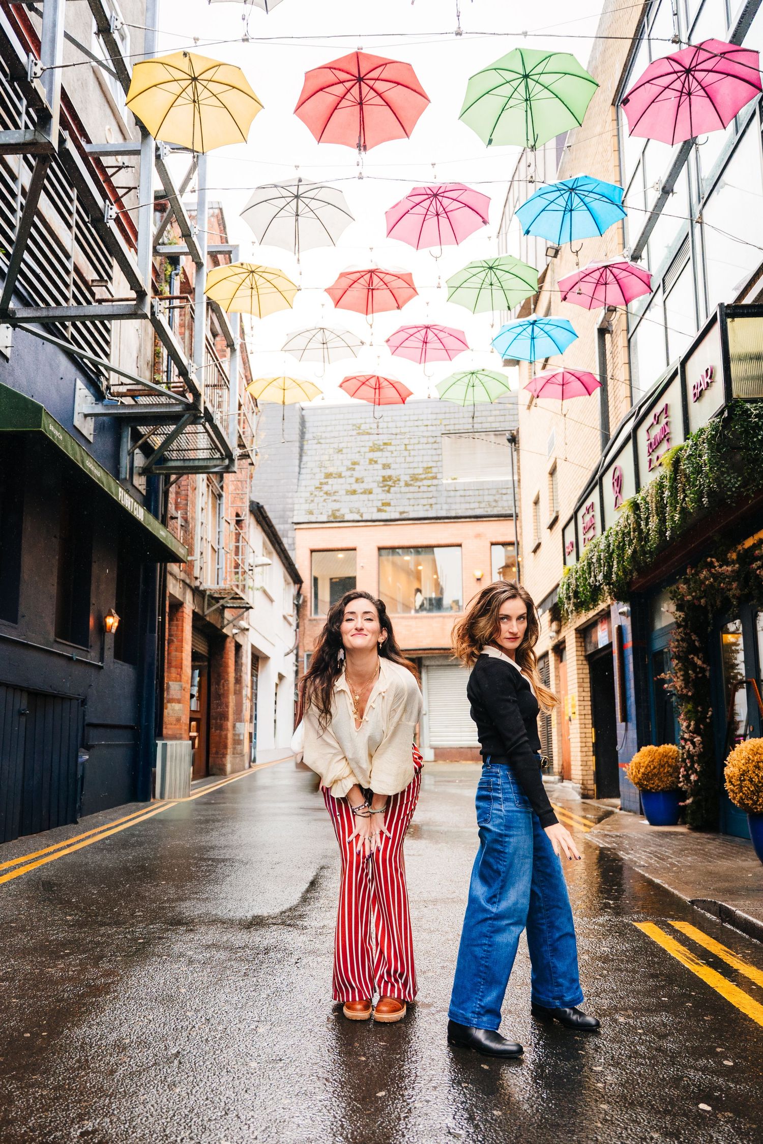 A charming alleyway decorated with colorful floating umbrellas creating a whimsical canopy overhead. professional headshots dublin photograp