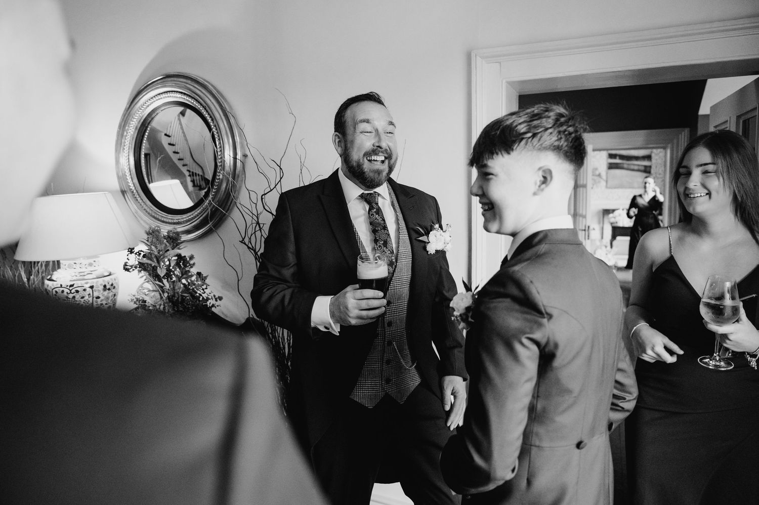 Virginia Park Lodge Wedding Photographer  guests enjoying drinks and socializing during a candid black and white reception celebration.