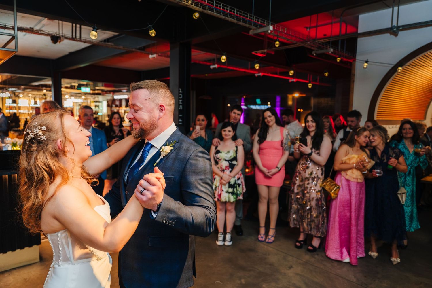 Wedding reception dance floor filled with guests celebrating under dim lighting. Dublin wedding photogrAPher