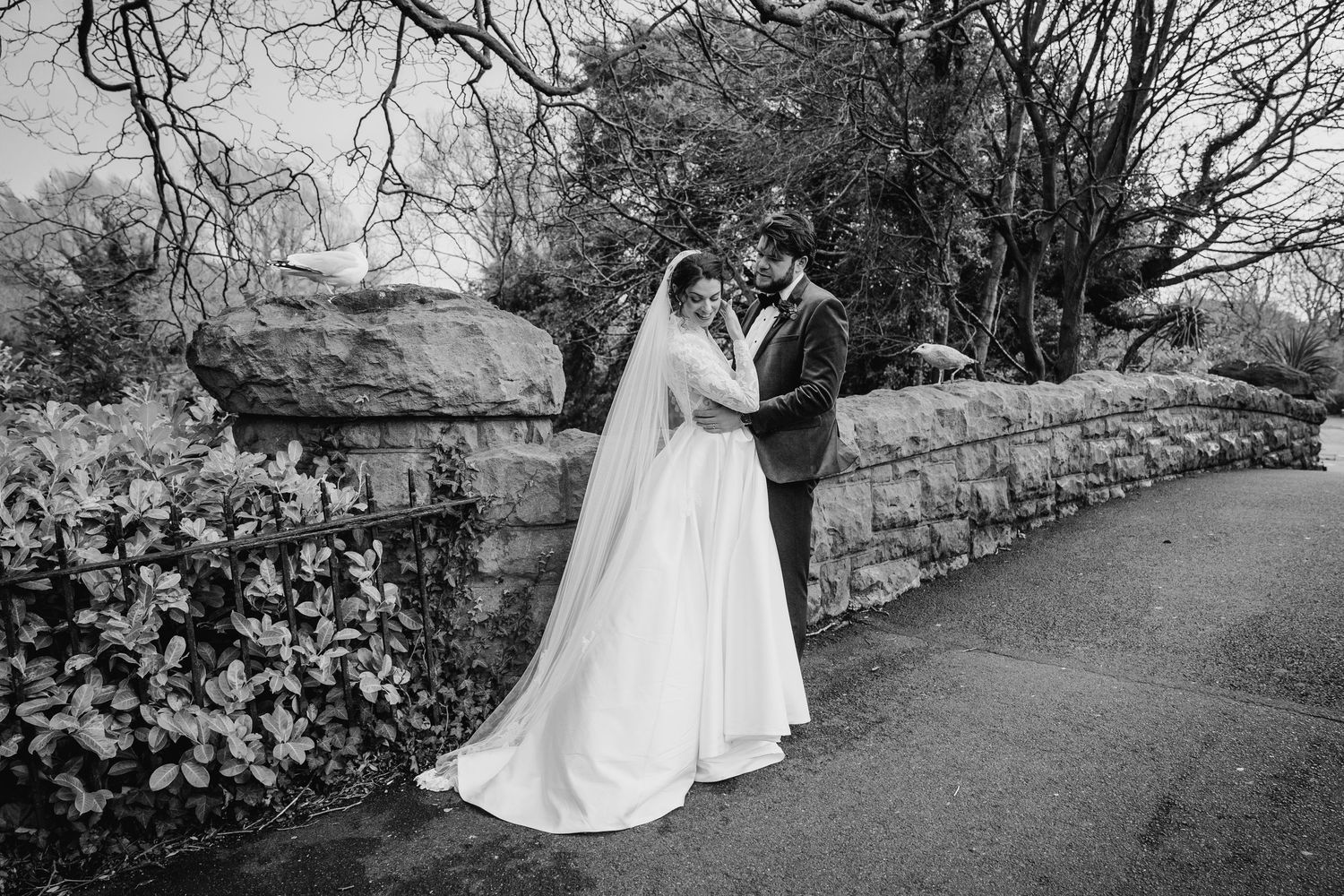 Elegant black and white wedding photos showing couple walking through garden pathway with stone walls. Stephens green club dublin Wedding ph
