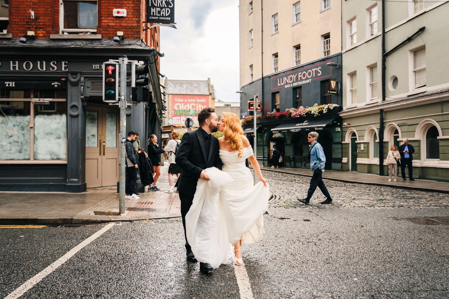 Wedding couple walking down urban street with historic buildings and storefronts.  city hall dublin wedding photos