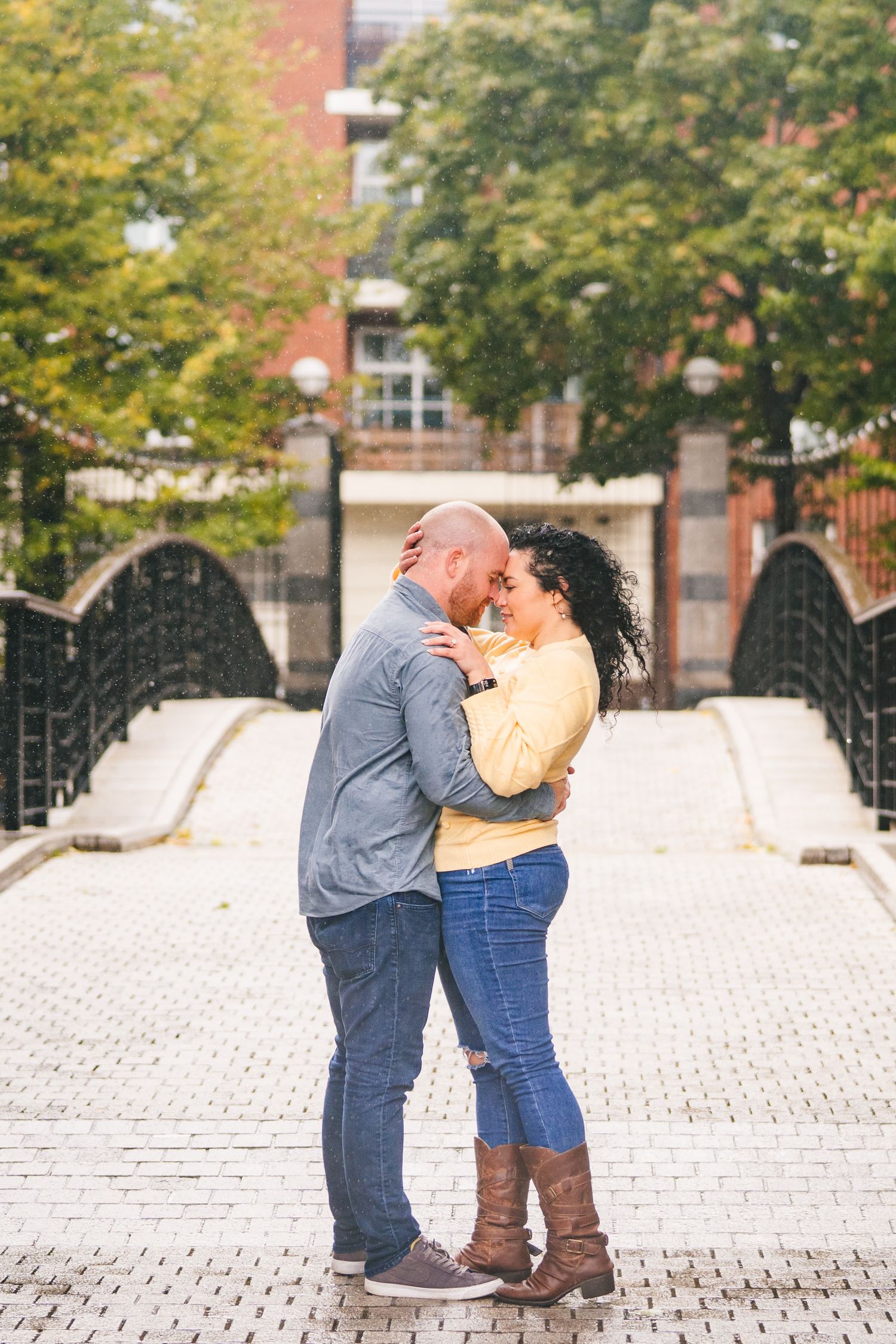 Couple sharing intimate moments on cobblestone plaza with autumn trees in background. Proposal Dublin Photographer