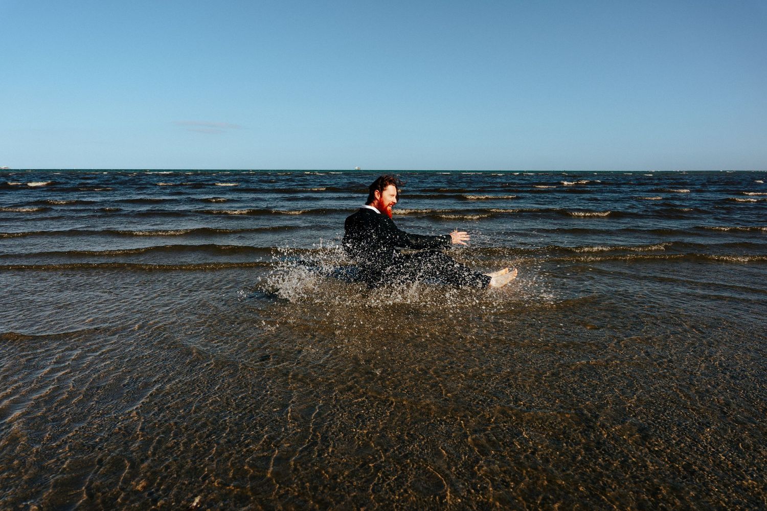 Person splashing and playing in ocean waves on a sunny day. PHOTOGRAPHER Dublin