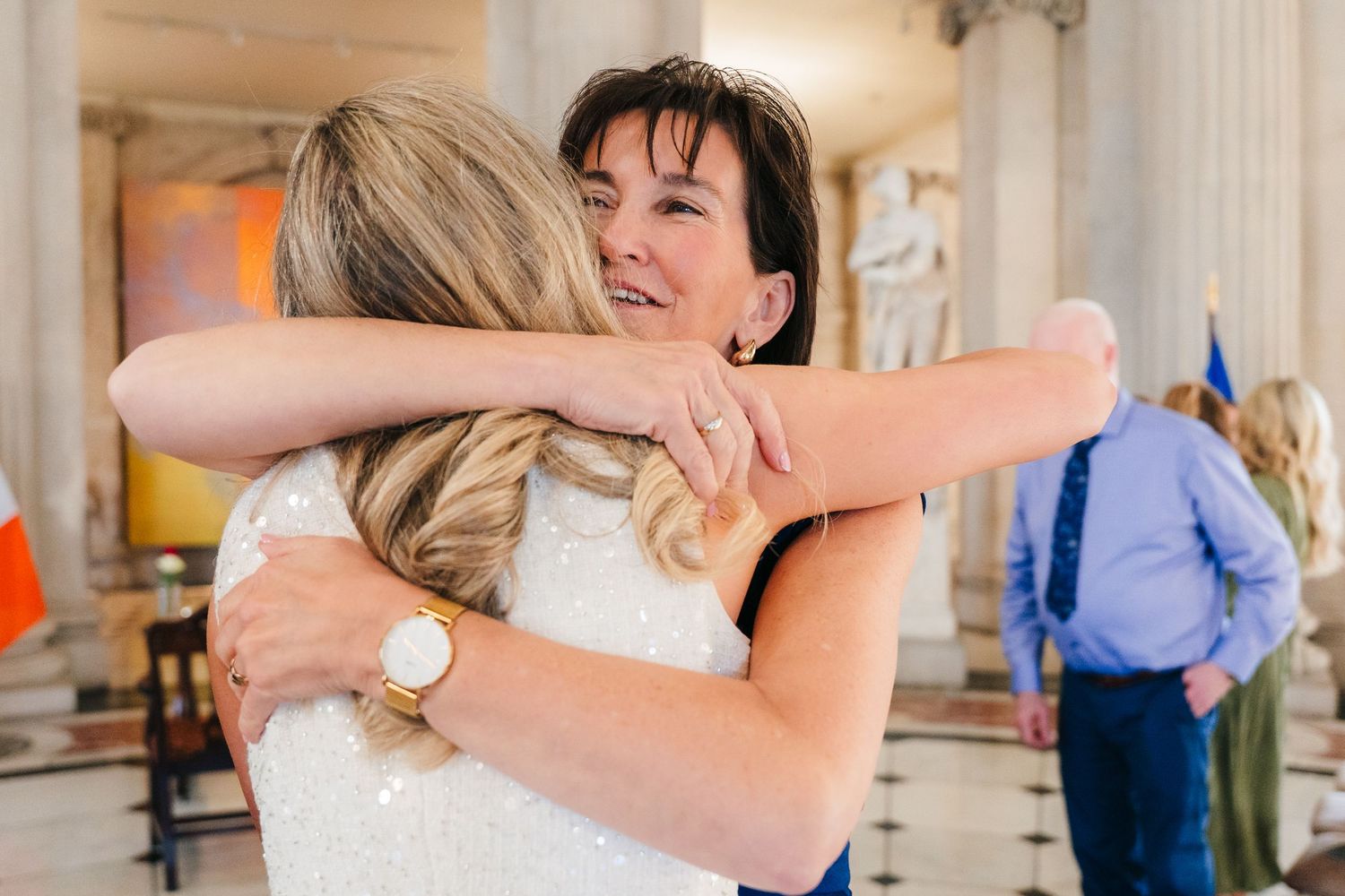 Candid moments of wedding guests embracing and celebrating in an ornate venue. City Hall Dublin wedding photogrAPher
