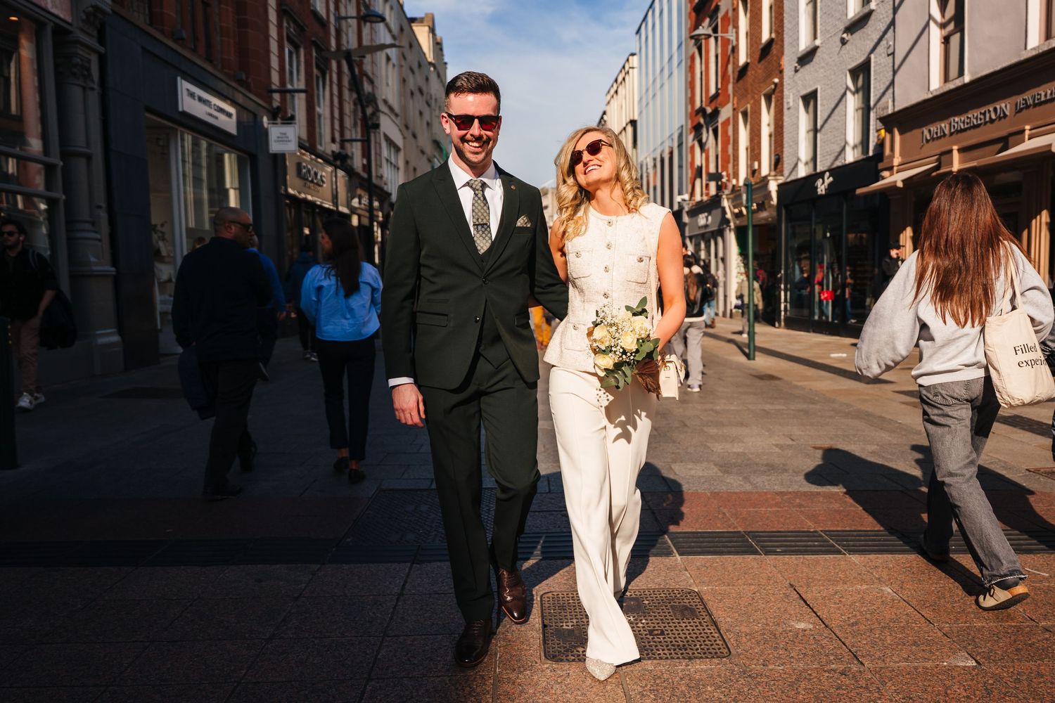 Couple walking down a historic brick street on a sunny afternoon. City Hall Dublin wedding photogrAPher