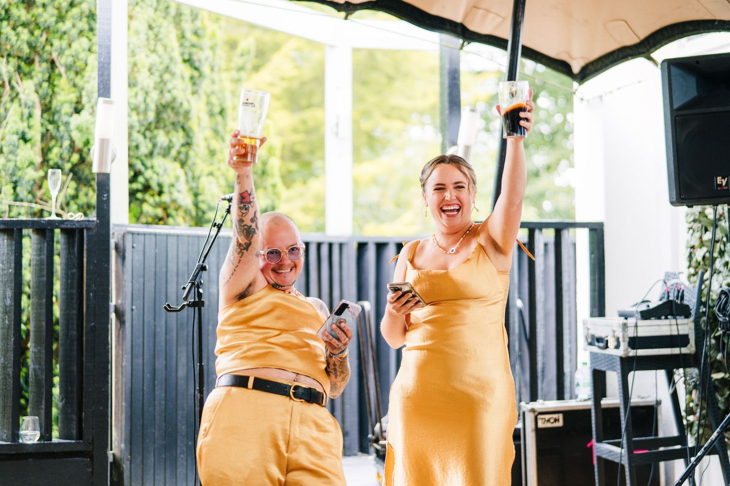Poulaphouca Wedding photographer wicklow  Outdoor wedding celebration under white umbrellas with people in gold attire.