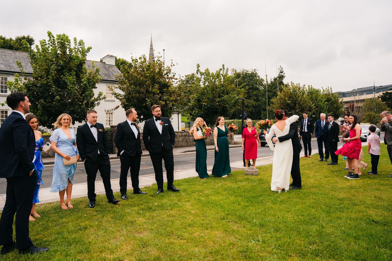 Wedding party and guests gather on a green lawn outside with formal attire. Wedding Photography Trim Castle Ireland