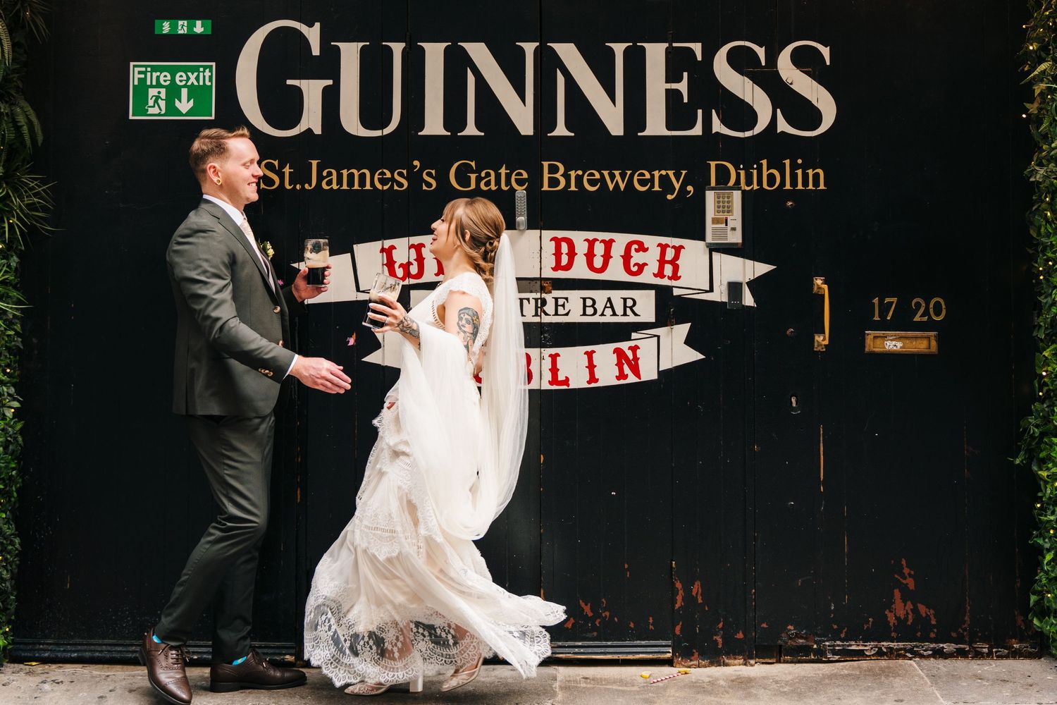 Newlyweds pose dramatically in front of the iconic Guinness Brewery gate in Dublin. PHOTOGRAPHER Dublin Ireland Wedding